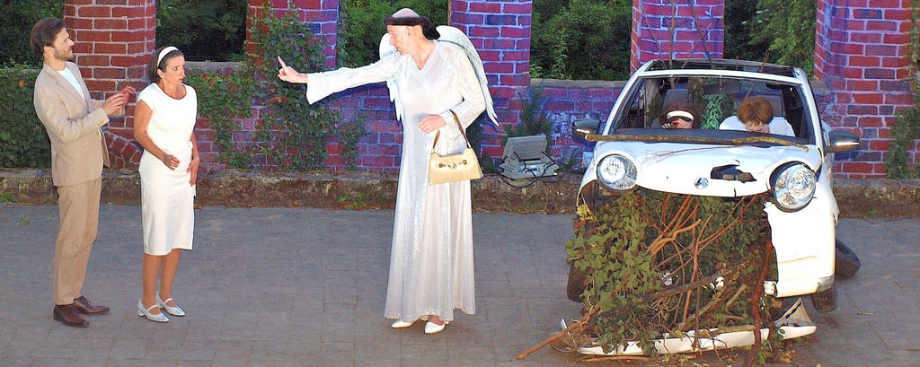 Sommertheater auf der Klosterbühne am Arendsee: Robert (Matthias Hinz) und Rita (Kerstin Slawek) begegnen am Unfallort, wo sie ihrem Autowrack entsiegen, der Himmelspfortenöffnerin Petra (Niclas Ramdohr).