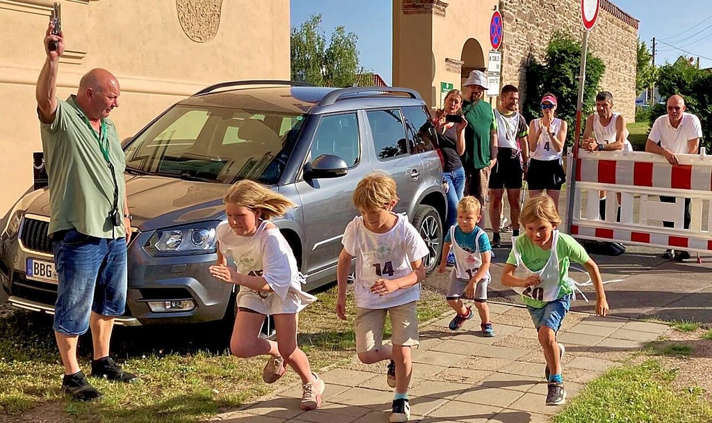 Aderstedts Ortsbürgermeister Mike Franzelius gibt den Startschuss für den Kinderwettbewerb beim Strengelauf.