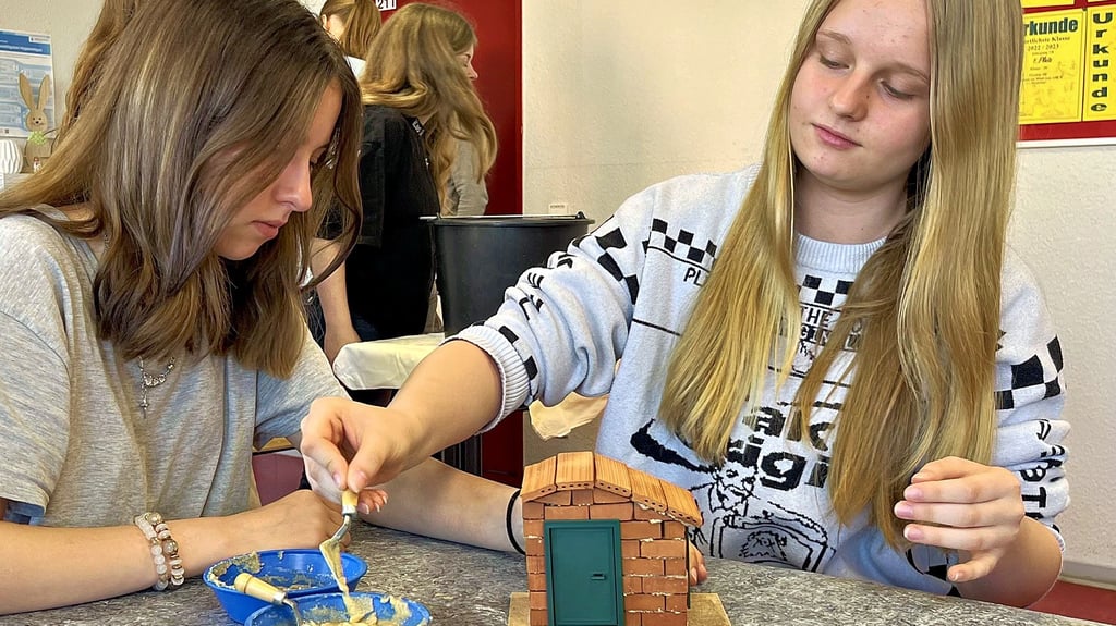 Die Schülerinnen Amalia Urban (rechts) und Melissa Heilemann bauen beim Berufetag in Tangermünde gemeinsam ein kleines Haus.