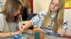 Die Schülerinnen Amalia Urban (rechts) und Melissa Heilemann bauen beim Berufetag in Tangermünde gemeinsam ein kleines Haus. 