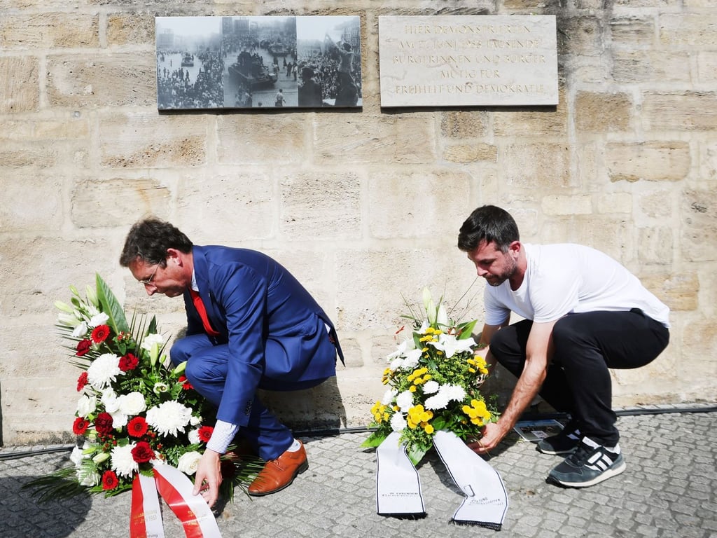 OB Alexander Vogt (parteilos) und Gedenkstättenpädagoge Niklas Poppe legten Kränze an der Gedenktafel am Hallmarkt nieder.