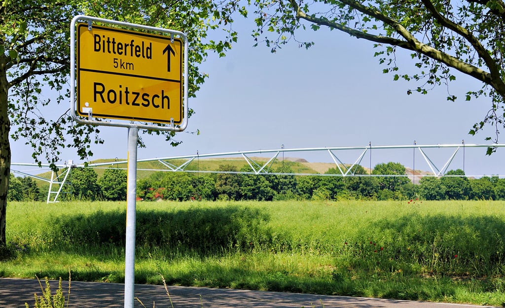 Sommerliches Grün und eine Beregnungsanlage verdecken den Blick auf die Hochmülldeponie – doch sie bleibt Thema in Roitzsch und Umgebung.