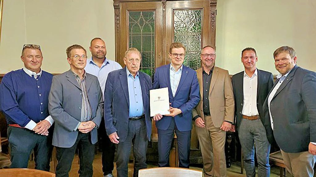 Staatssekretär Sven Haller (M.) übergibt den Fördermittelbescheid über 200.000 Euro.