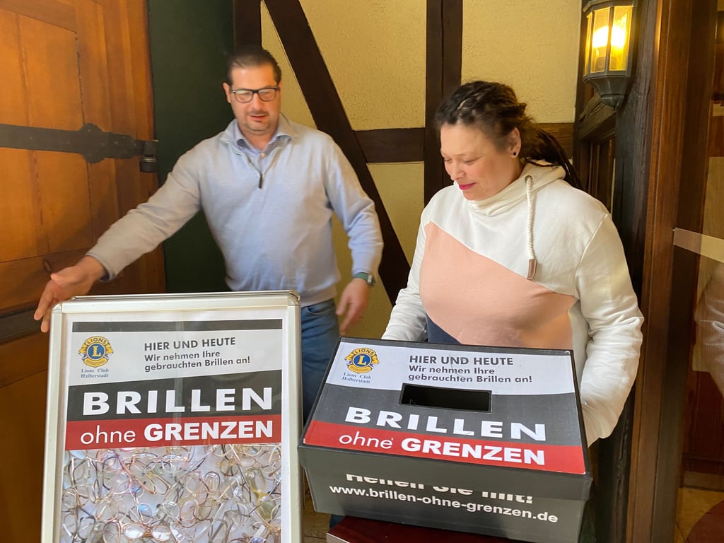 René Mittag und Iris Kenull mit Sammelbox und Aufsteller die Brillen-Sammel-Aktion des Lions Clubs. Gesammelt wird auch wieder bei den Sommerhöfen in Halberstadt.