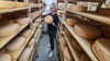 Linda BeckerBauer. Geschäftsführerin der"Bauer Freigeist GmbH" Gardelegen und dem Usbeken Ilkomjon Kodirov, der seit sechs Monaten als Käser in der Molkerei arbeitet, mit dem Gewinnerkäse in der Käsekammer.
