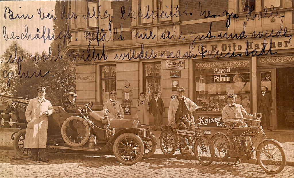 In das Jahr 1911 geht der Blick zurück in die lebhafte Vergangenheit des Hauses Wasservorstadt 18 in Zeitz. Für den Fotografen haben sich ganz offensichtlich ein frühes Automobil und zwei Motorräder in Stellung gebracht. Aus heutiger Sicht nicht minder interessant ist das zum Kauf verlockend gestaltete Schaufenster des Kolonialwarenladens C. F. Otto Hayner, dessen damaliger Inhaber August Hoppe, ein Kaufmann alter Schule, in der Tür steht.