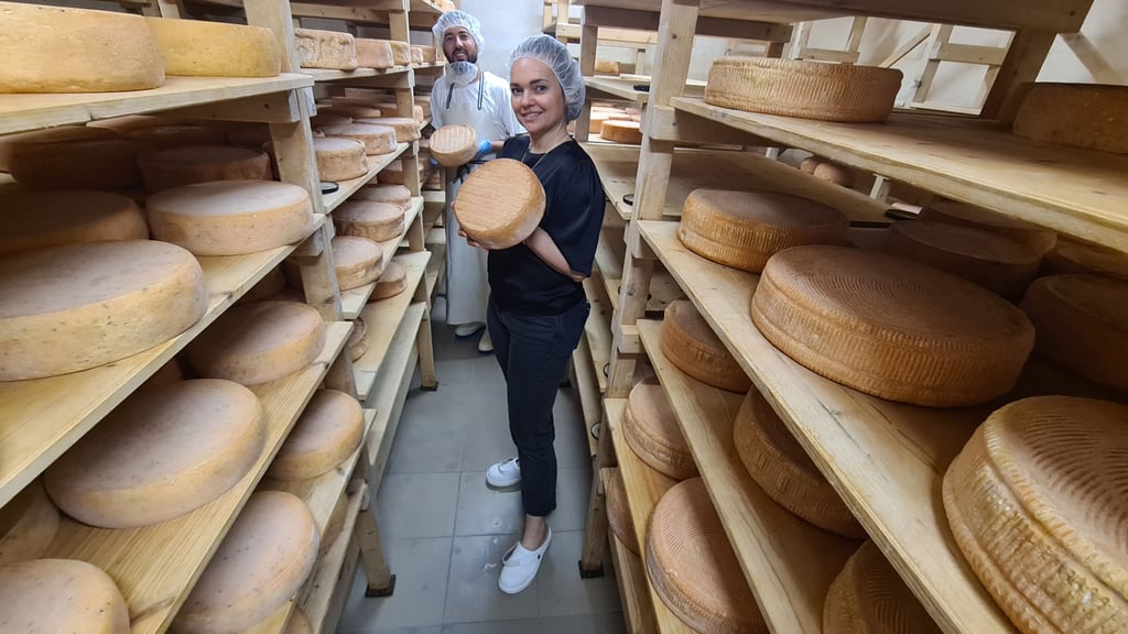 Linda Becker, Geschäftsführerin der"Bauer Freigeist GmbH" Gardelegen umit dem Usbeken Ilkomjon Kodirov, der seit sechs Monaten als Käser in der Molkerei arbeitet, mit dem Gewinnerkäse in der Käsekammer.