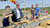 Jennifer Gores und Florian Herm schlugen beim Richtfest für den Norma-Neubau in Loburg symbolische Nägel ein, Polier Andy Kintra und Dachdeckermeister Marcel Leo zählten die Schläge mit.