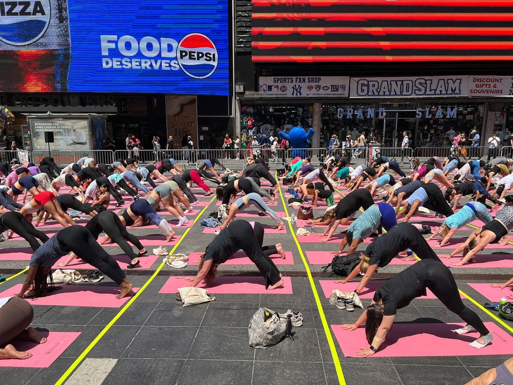 Trotz Hitzewelle versammeln sich Hunderte für Yoga auf dem Times Square.
