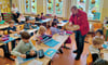 Uwe Ahrends vom Auto Club Europa ( ACE ) verteilte an die ersten Klassen  der Perver Grundschule Reflektorbänder und kleine Bücher. 