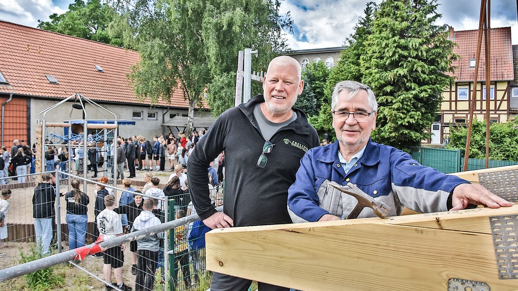 Dachdecker Fred Ebeling (Mitte) aus Haldensleben verkündet traditionell den Richtspruch, während Calvördes Bürgermeister Hubertus Nitzschke den letzten Nagel ins Holz des Dachstuhls einschlägt.