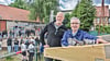 Dachdecker Fred Ebeling (Mitte) aus Haldensleben verkündet traditionell den Richtspruch, während Calvördes Bürgermeister Hubertus Nitzschke den letzten Nagel ins Holz des Dachstuhls einschlägt. 