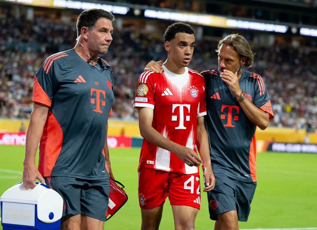 Jamal Musiala musste nur 25 Minuten nach seiner Einwechselung angeschlagen vom Platz, begleitet von Teamarzt (r) und Physiotherapeut.