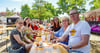 Besucher des Oschersleber Stadtfestes lassen es sich in einem schattigen Plätzchen vor der Bühne am Hackelberg gut gehen.