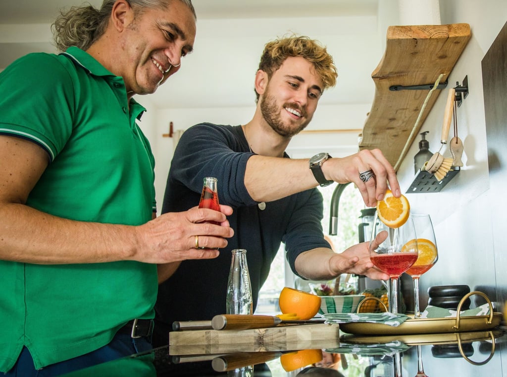 Freude am Experimentieren: Freunde bereiten in der heimischen Küche einen alkoholfreien Aperitif mit Sanbitter zu. Er ist für seine rote Farbe und bittersüße, herbe Geschmacksnote bekannt.