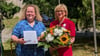 Cathleen Brand (liniks) überreicht Maria Oppermann die Ehrennadel der Caritas.