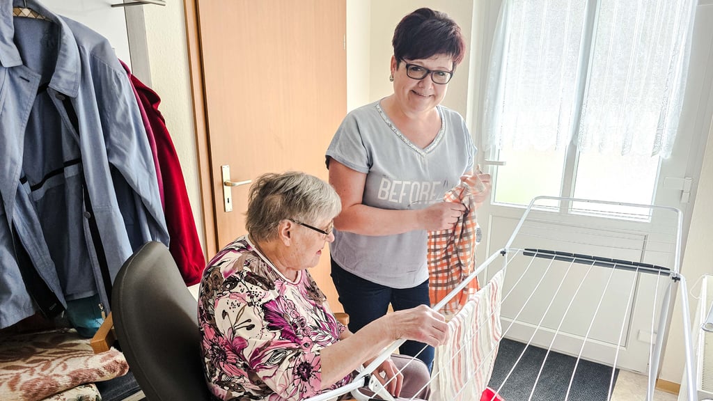 Gertrud Schulz und Maren Haberland hängen gemeinsam Wäsche auf. Die Alltagsbegleiterin unterstützt die Seniorin dabei, so lange wie möglich selbstbestimmt im eigenen Zuhause zu leben.