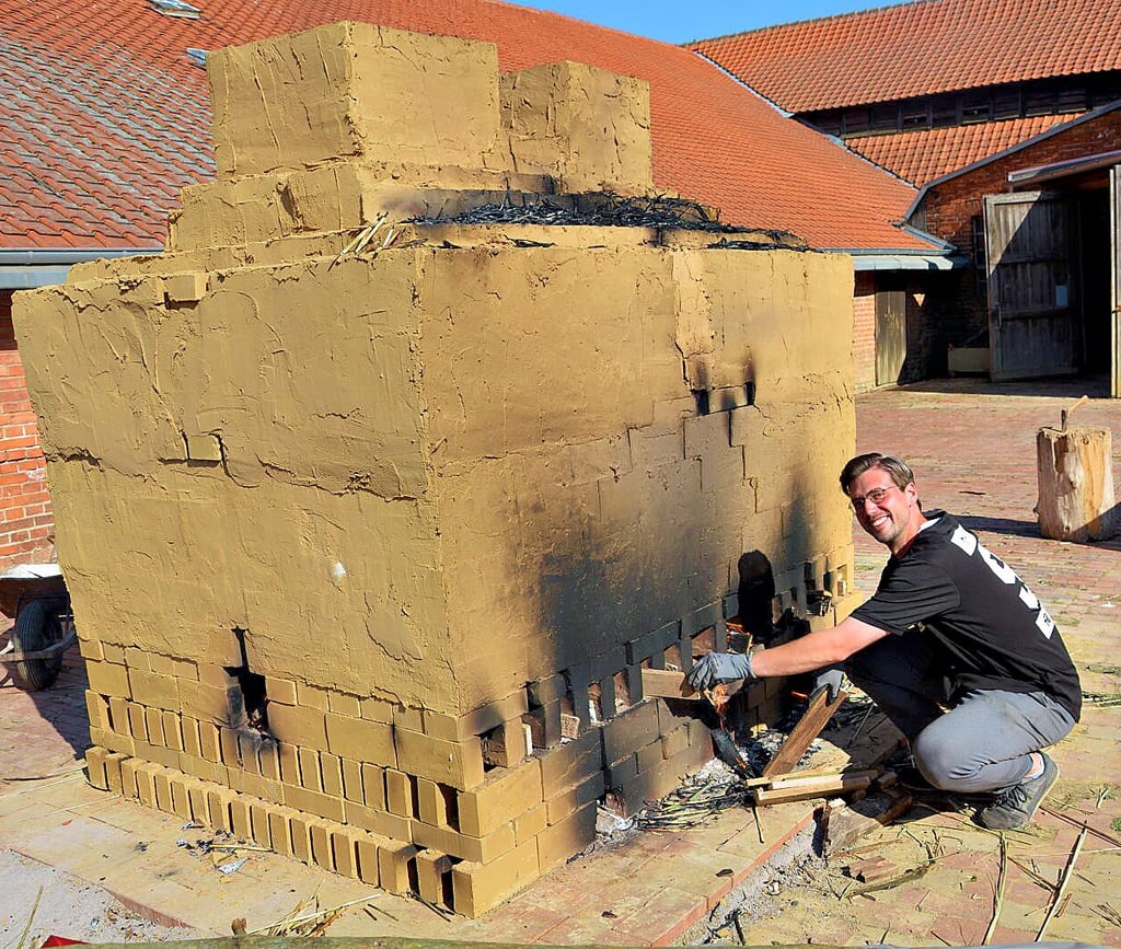 Museumsleiter Marian Heiß befeuert den extra für den Brennerabend aufgebauten Feldbrandofen.