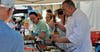 Koch Oliver Skoluda (rechts) bot beim Sommerfest verschiedene gesunde Gerichte an. Davon machten die Besucher auch reichlich Gebrauch. 