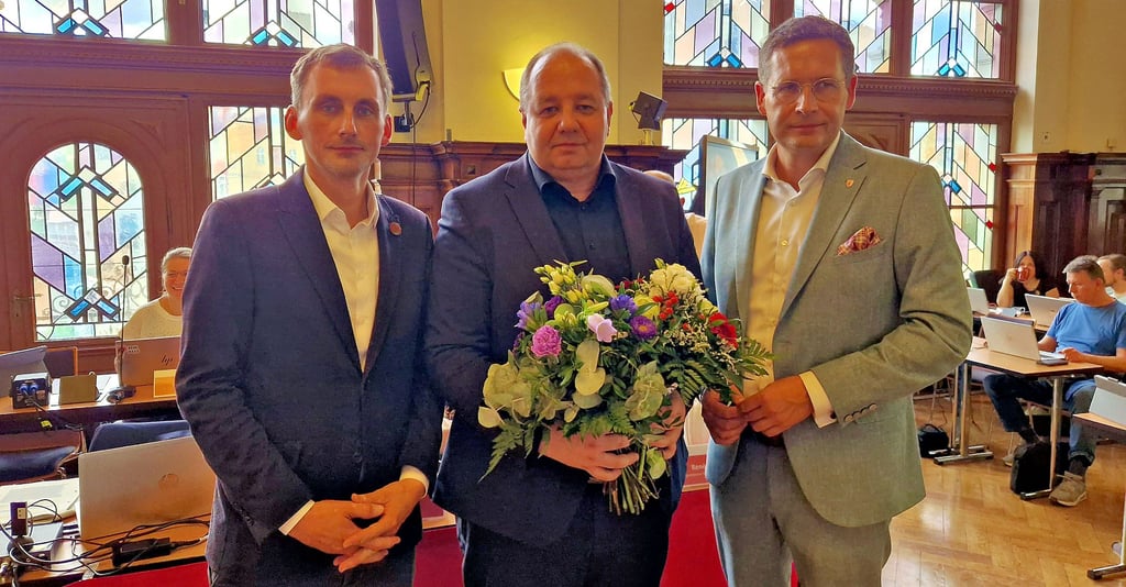 Ratsvorsitzender Jan Riedel (links, CDU) und Oberbürgermeister Alexander Vogt (rechts, parteilos) gratulierem René Rebenstorf zur Wiederwahl.
