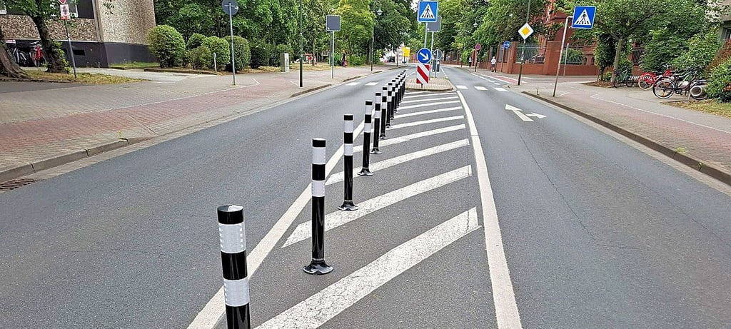 Die Poller stehen vor dem Zebrastreifen.