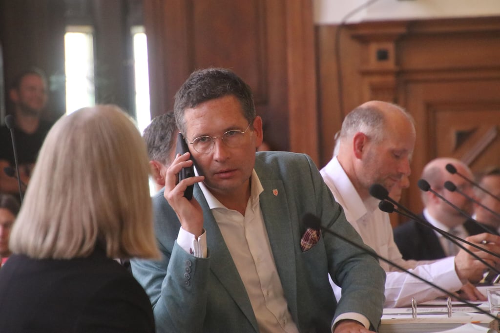 Halles Oberbürgermeister Alexander Vogt (parteilos) griff während einer kurzen Debattenpause im Stadtrat zum Handy. Er wurde unter anderem für seinen Vorstoß zum Hansetag 2034 kritisiert.