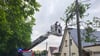 Feuerwehr und Stromversorger beraten, wie der Ast von der Stromleitung entfernt werden kann.