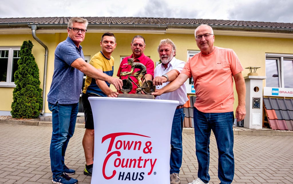 Das Organisationsteam für das Wittenberger Profirennen präsentiert den Pokal für den Sieger.