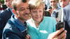Bald zehn Jahre her: Angela Merkel (CDU) lässt sich nach dem Besuch einer Erstaufnahmeeinrichtung für Asylbewerber in Berlin-Spandau für ein Selfie zusammen mit einem Flüchtling fotografieren. (Archivbild)