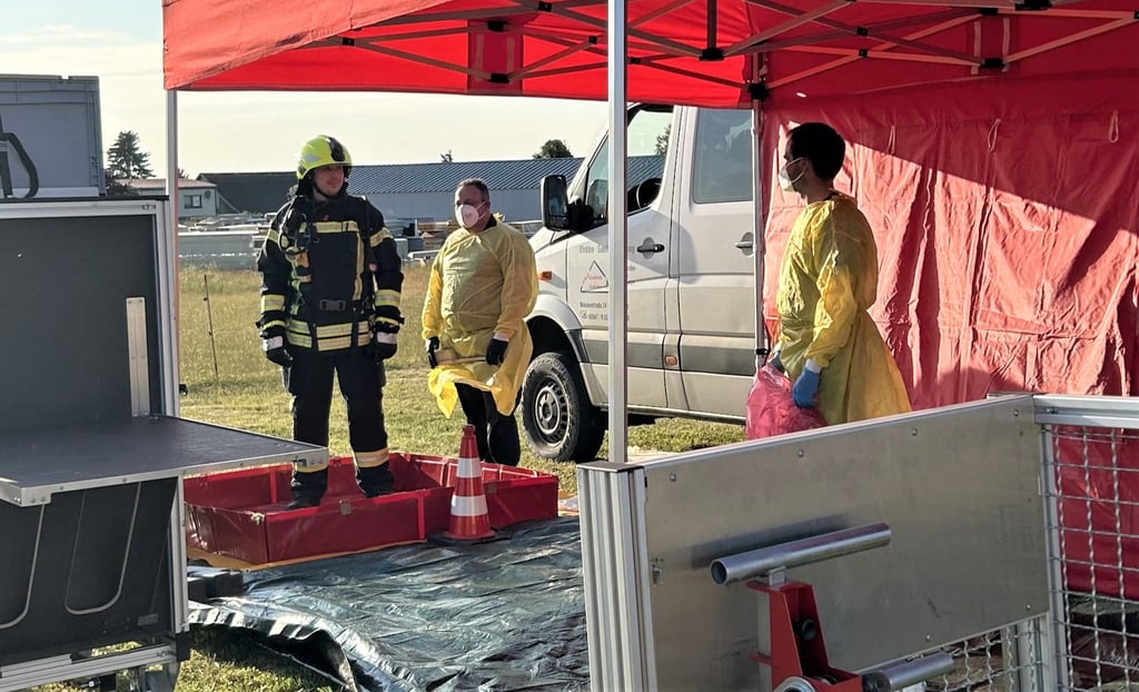 An der Hygienestrecke warten schon zwei Helfer, die die kontaminierte Einsatzkleidung für die Reinigung luftdicht verpacken.