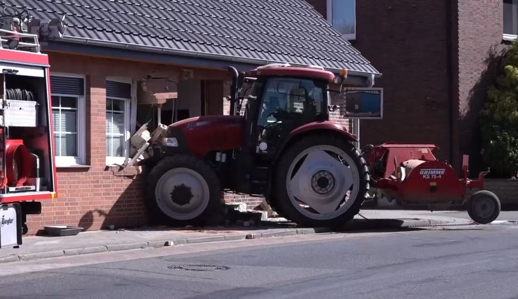 Ein Traktor steckt in einer stark beschädigten Hauswand. Wich der Fahrer einem Schulbus aus?