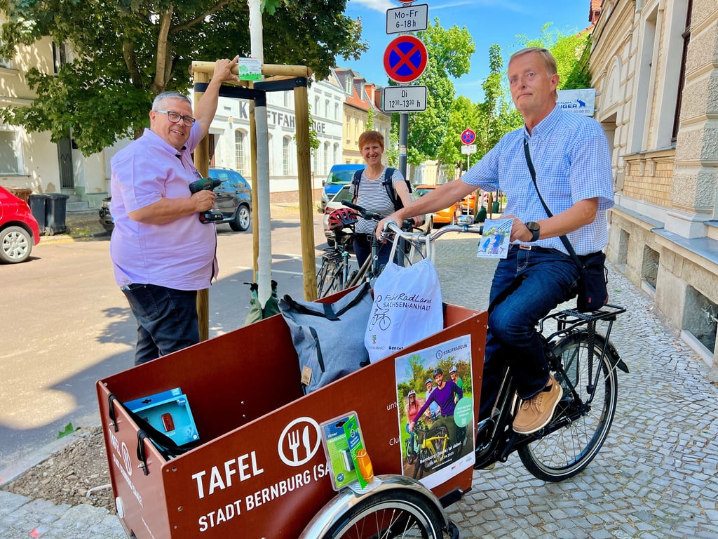 Michael Angermann (links), Präsident des SC Bernburg, schraubte in der Vorwoche an der Hohen Straße im Beisein von Julia Tarlatt und Jens Meißner das Siegerschild vom Stadtradeln 2024 an den neu gepflanzten Baum.