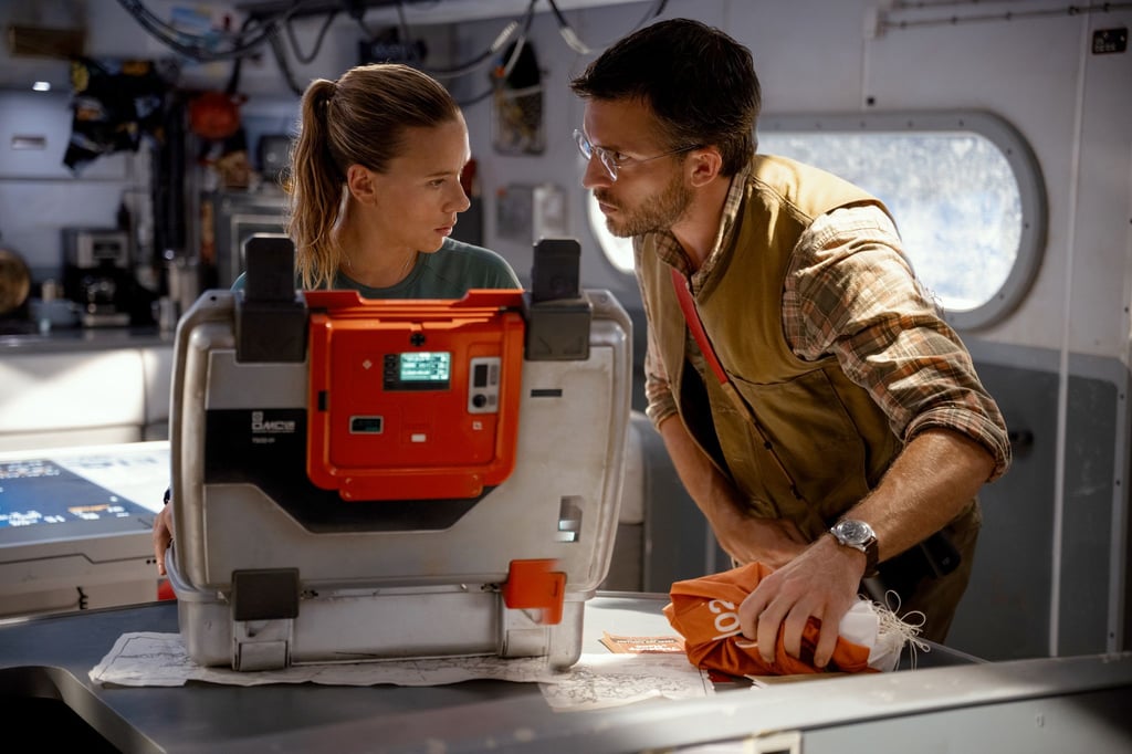 Scarlett Johansson (l) als Zora Bennett und Jonathan Bailey als Dr. Henry Loomis in einer Szene des Films „Jurassic World: Die Wiedergeburt“.