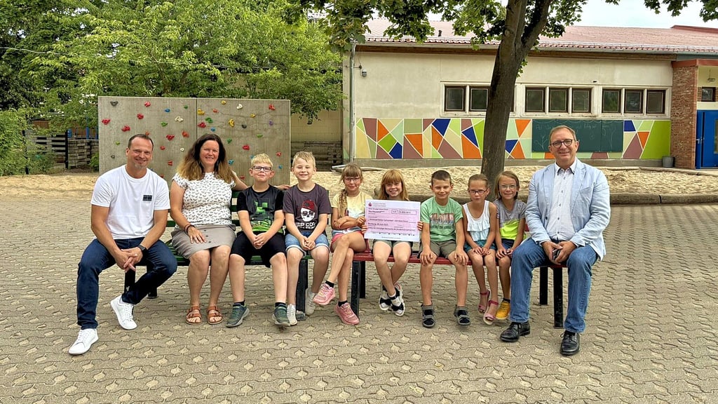 Ortsbürgermeister, Schulleiterin Landrat mit Vierklässlern der Grundschule "An der Mühle" Sachsendorf, die sich über den symbolischen Scheck der Sparkasse freuen.
