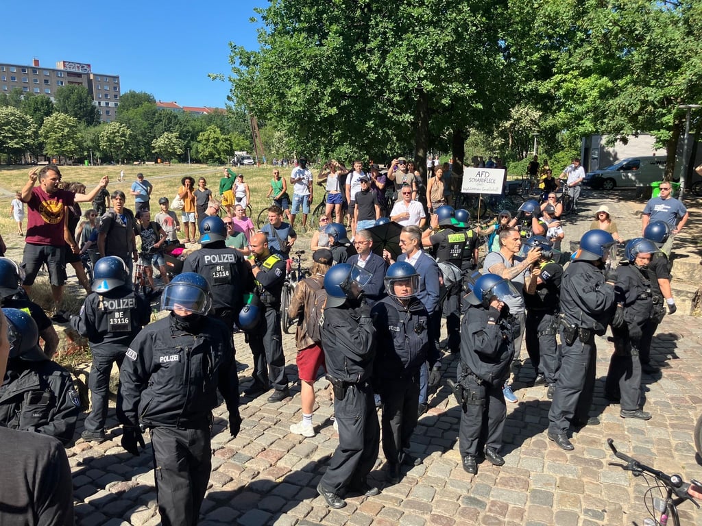 Demonstrierende und Polizisten stehen im Görlitzer Park.