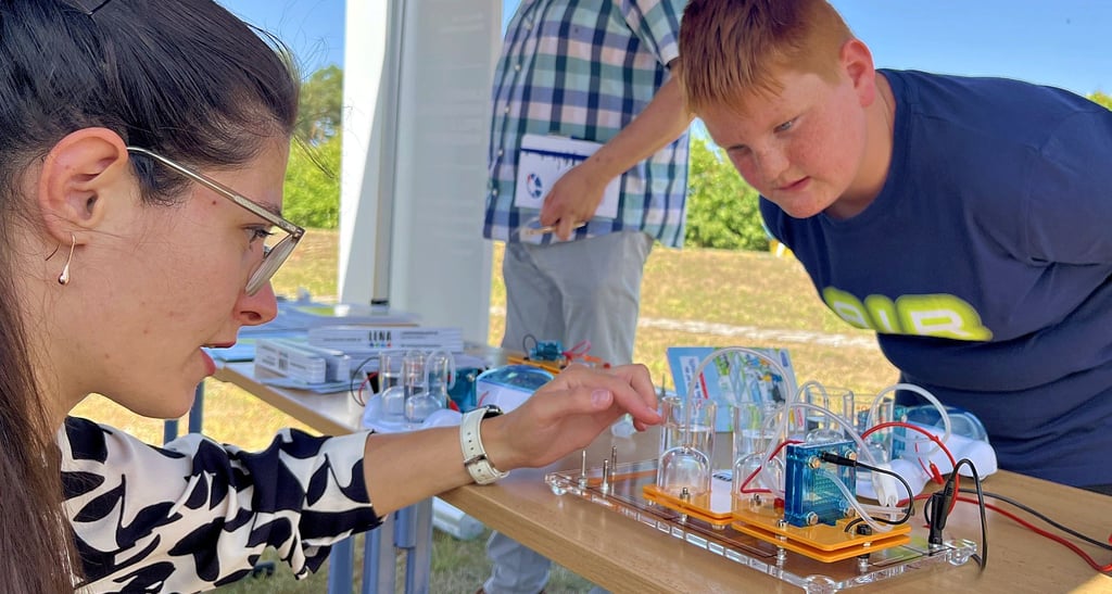 Linus Zabel (12) interessiert sich für die Experimente der Landesenergieagentur. Giulia Slaviera (links) erläutert die Gewinnung von Wasserstoff mittels Elektrolyse aus Solarstrom.