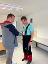 Tobias Federwisch (links) passt für Michel Steiner von der Feuerwehr Badersleben die neue einsatzkleidung an. 