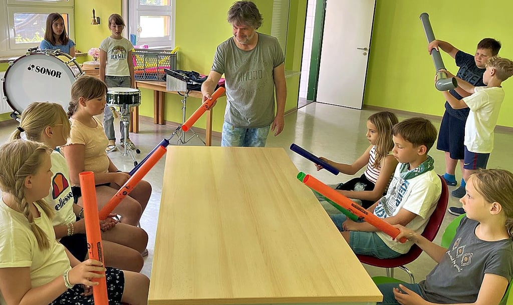 Guido Käpernick (Mitte) übt mit einem Teil der Schüler die Reihenfolge der unterschiedlich hohen Töne der dicken Kunststoffrohre ein.