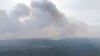Bei dem Waldbrand in der Gohrischheide erkundet ein Hubschrauber die Brandfläche.