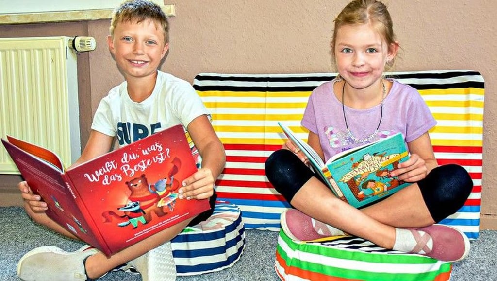 Oskar (8) und Mara (7) testen die bequemen Sitzmöglichkeiten der Bibliothek, die im Dachgeschoss der Grundschule Nonnewitz entsteht.
