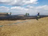 Die Feuerwehr löscht den Brand auf einem Feld. 