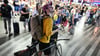 Passagiere sitzen in der Halle des Prager Hauptbahnhofs wähtrend eines Stromausfalls. Ein Stromausfall hat am Freitag große Teile Tschechiens und der Millionenmetropole Prag lahmgelegt.