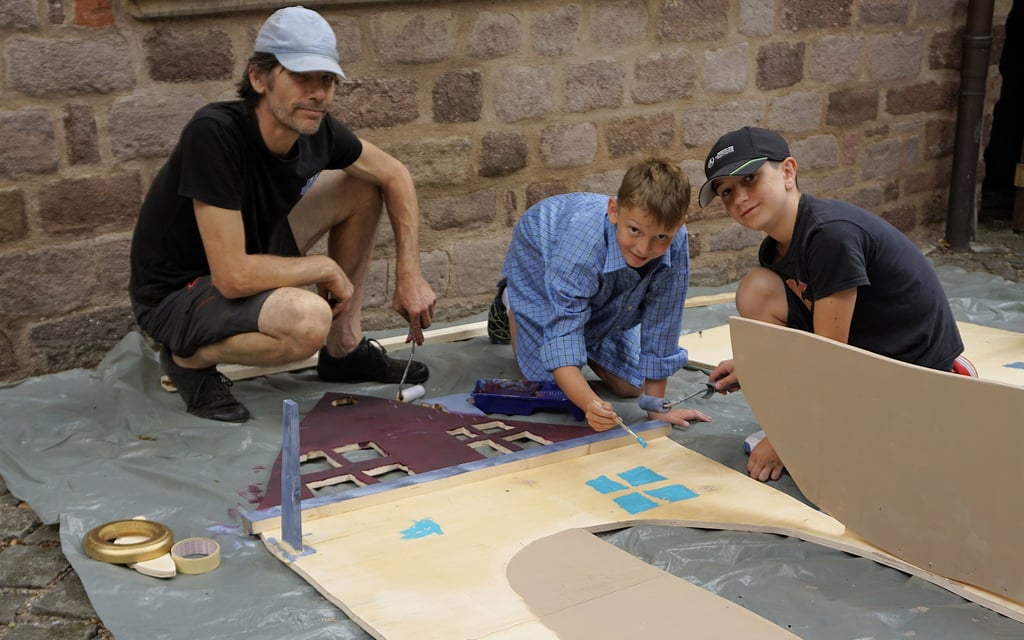 Simon (Mitte) und Oscar beim Streichen ihre Hausfassade unter Anleitung von Christian Wenzel.