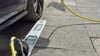 Ein E-Auto lädt an einem Ladebordstein. Die E-Ladebordsteine waren ein Pilotprojekt in Köln. In Magdeburg soll die Möglichkeit nun auch geprüft werden.