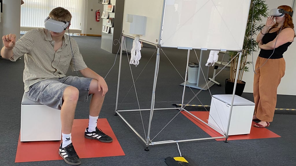 Greifen ins Leere - mit der VR-Brille taucht man in andere Welten. Johannes Hahne aus Wernigerode und Charlotte Deutschbein aus Quedlinburg verschaffen sich im BiZ, dem Berufsinformationszentrum der Agentur für Arbeit Halberstadt, einen Eindruck von der Arbeitswelt der Zukunft.