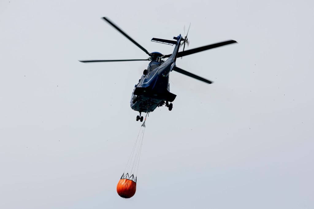 Ein Löschhubschrauber der Bundespolizei fliegt über dem Zeithainer Tagebau und nimmt Wasser auf, um den Waldbrand Gohrischheide zu bekämpfen.