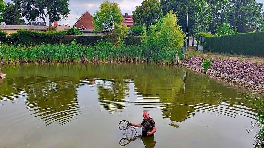 Michael Warthemann von der Poleyer Angelgruppe bringt die Schläuche in den Teich.