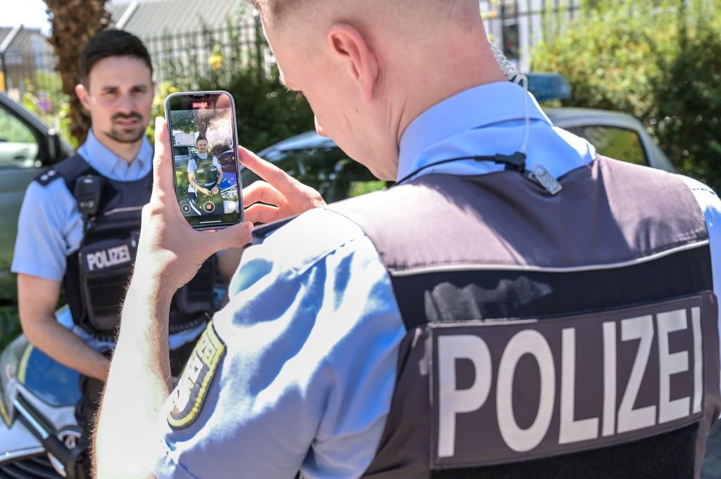 Polizeihauptkommissar Sebastian Schultzik (l) und Polizeimeister Arthur Gamm filmen eine neue Videoszene.