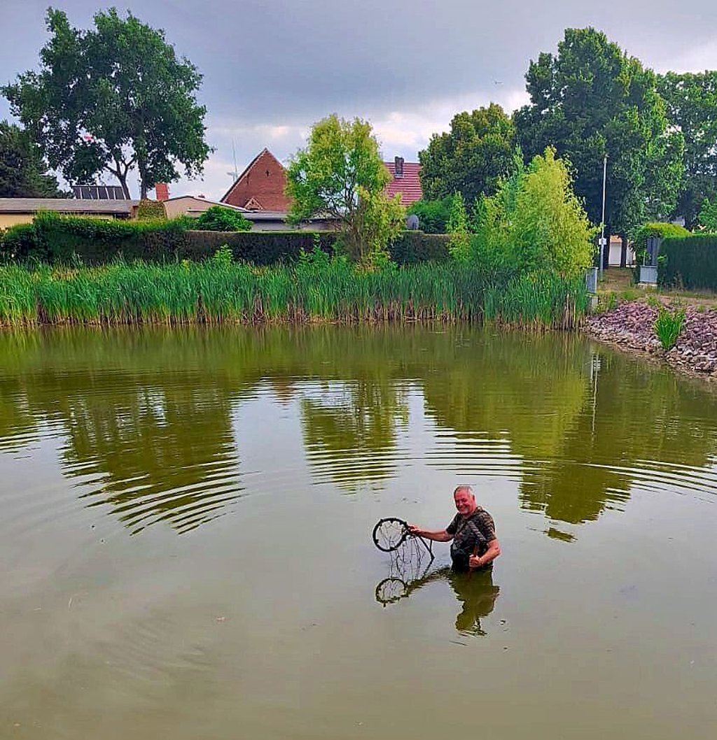 Michael Warthemann bringt die Schläuche in den Teich.