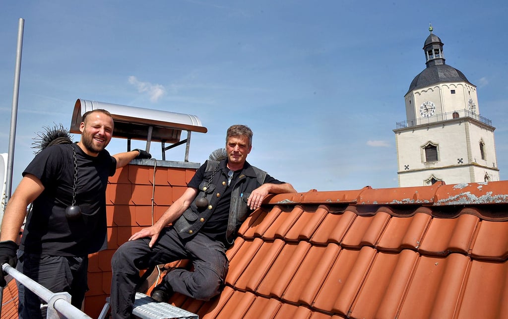 Geselle Paul Garke (links) und Schornsteinfegermeister Kay Reinefeld an einem Schlot in der Innenstadt.
